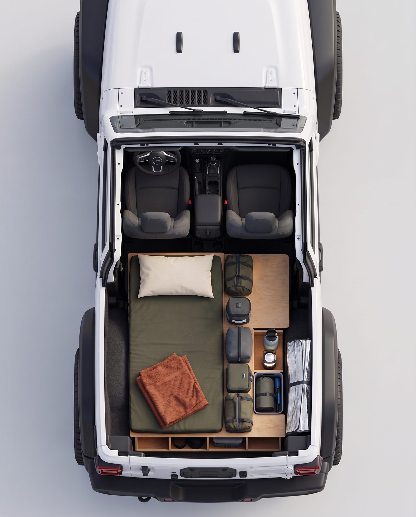 Overhead view of a white two-door Jeep Wrangler with a sleeping platform, pillow, blanket, wood storage shelves, and camping gear packed to scale